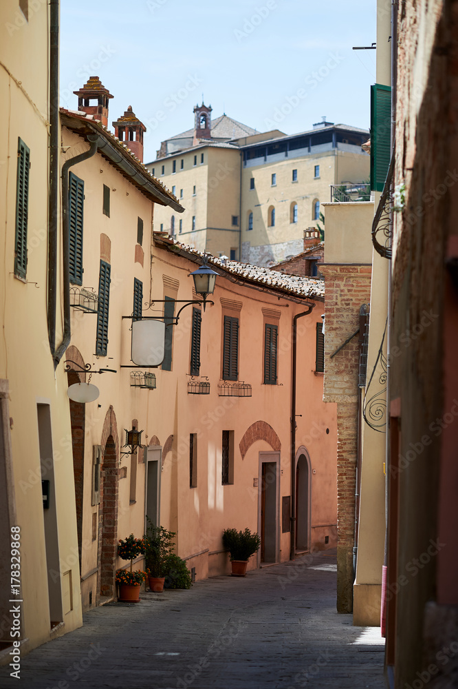 A street with colorful houses and two blank signs in Montepulciano, Tuscany, Italy