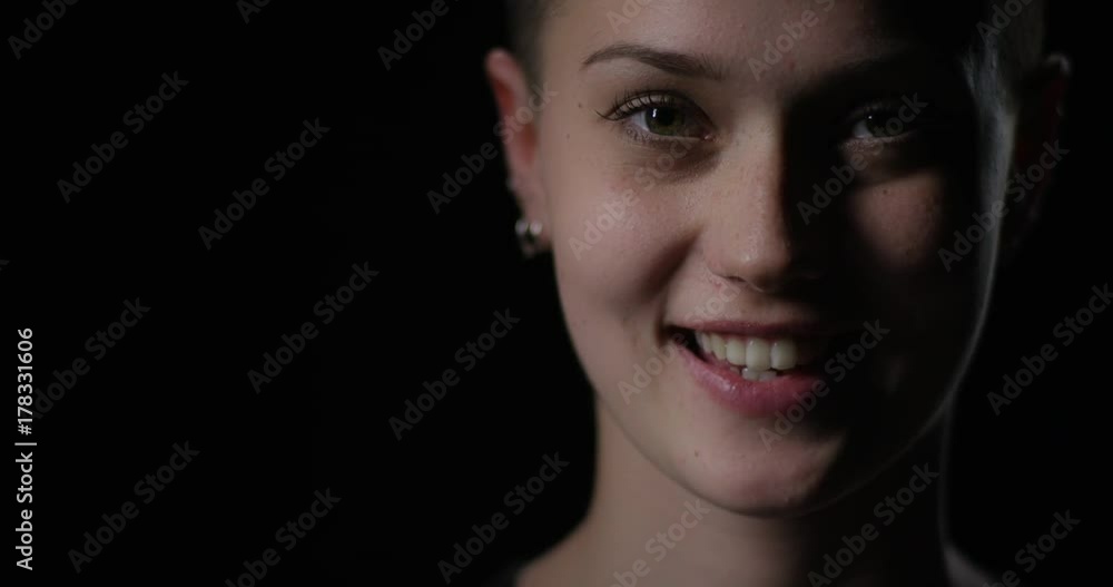 Young beautiful woman opens eyes and smiles into camera Young beautiful woman opens eyes and smiles into camera