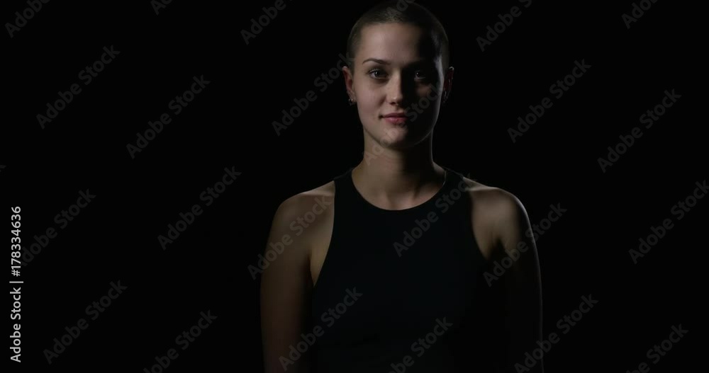 Young short haired woman steps out of the dark Young short haired woman steps out of the dark