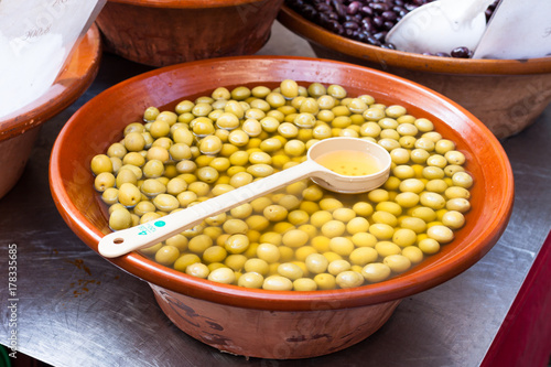 Pickled green olives for sale in a boil with a spoon at Sineu market, Majorca, Spain