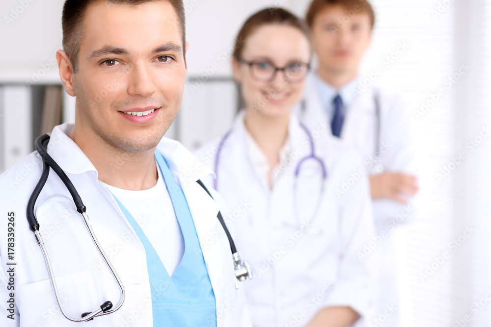 Cheerful smiling male doctor with medical staff at the hospital Cheerful smiling male doctor with medical staff at the hospital
