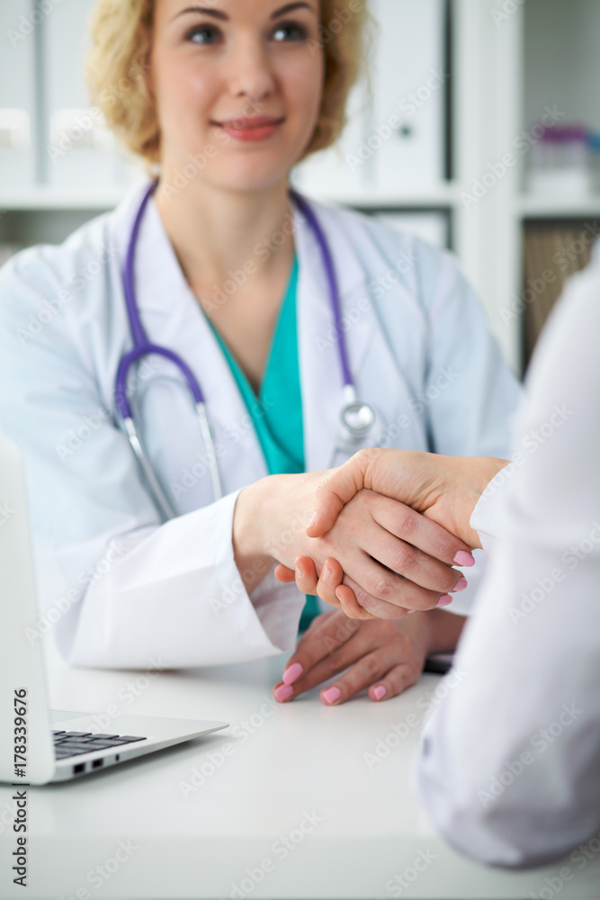 Doctor and patient shaking hands, close-up. Physician talking about medical examination results. Medicine, healthcare and trust concept Doctor and patient shaking hands, close-up. Physician talking about medical examination results. Medicine, healthcare and trust concept