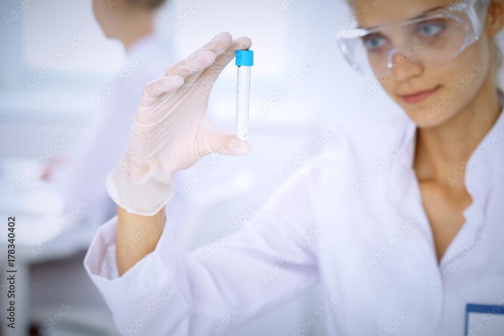 Female scientific researcher in laboratory studying substances or blood sample. Medicine and science concept Female scientific researcher in laboratory studying substances or blood sample. Medicine and science concept