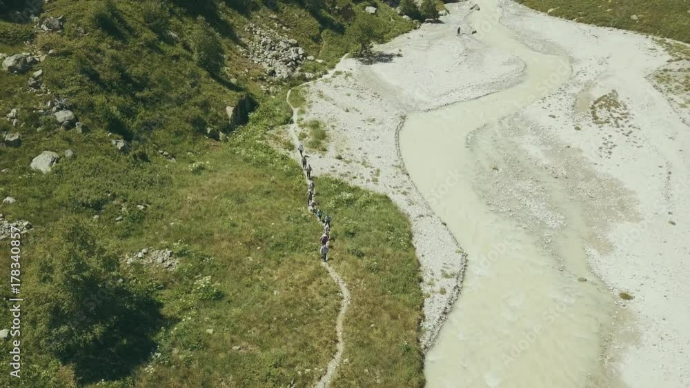 Hiking group walking along mountain river on summer day. Mountain landscape Hiking group walking along mountain river on summer day. Mountain landscape