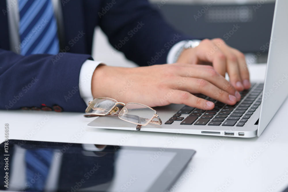 Businessman working by typing on laptop computer. Man's hands on notebook or business person at workplace. Employment or start-up concept Businessman working by typing on laptop computer. Man's hands on notebook or business person at workplace. Employment or start-up concept