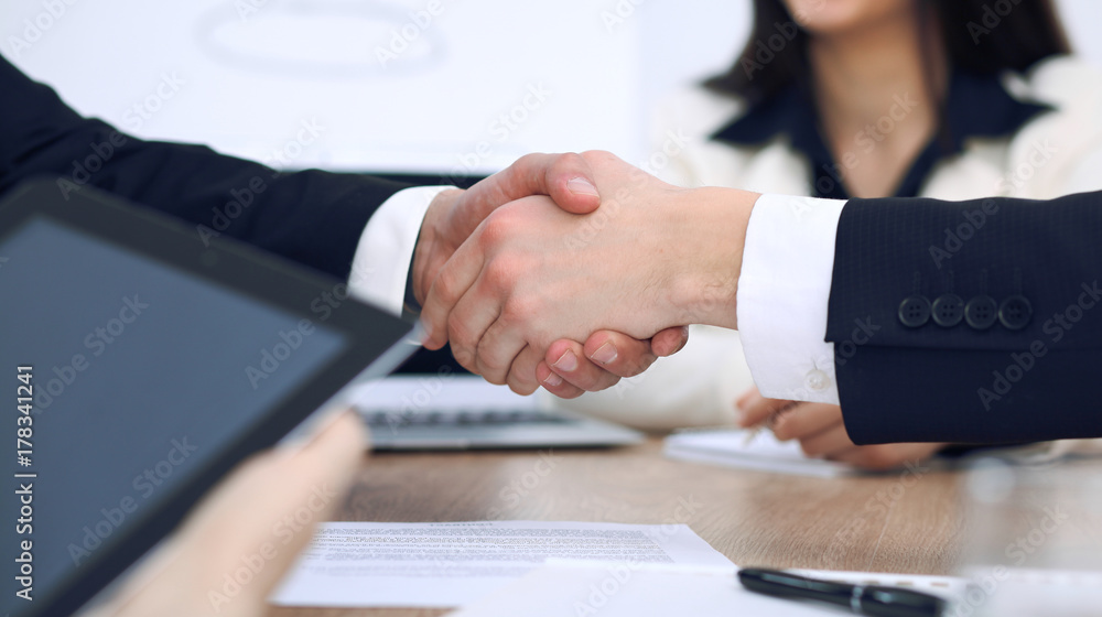 Close up of business people shaking hands at meeting or negotiation in the office. Partners are satisfied because signing contract Close up of business people shaking hands at meeting or negotiation in the office. Partners are satisfied because signing contract
