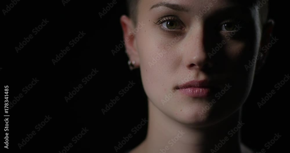 Beautiful girl with short hair opens eyes and looks into camera Beautiful girl with short hair opens eyes and looks into camera