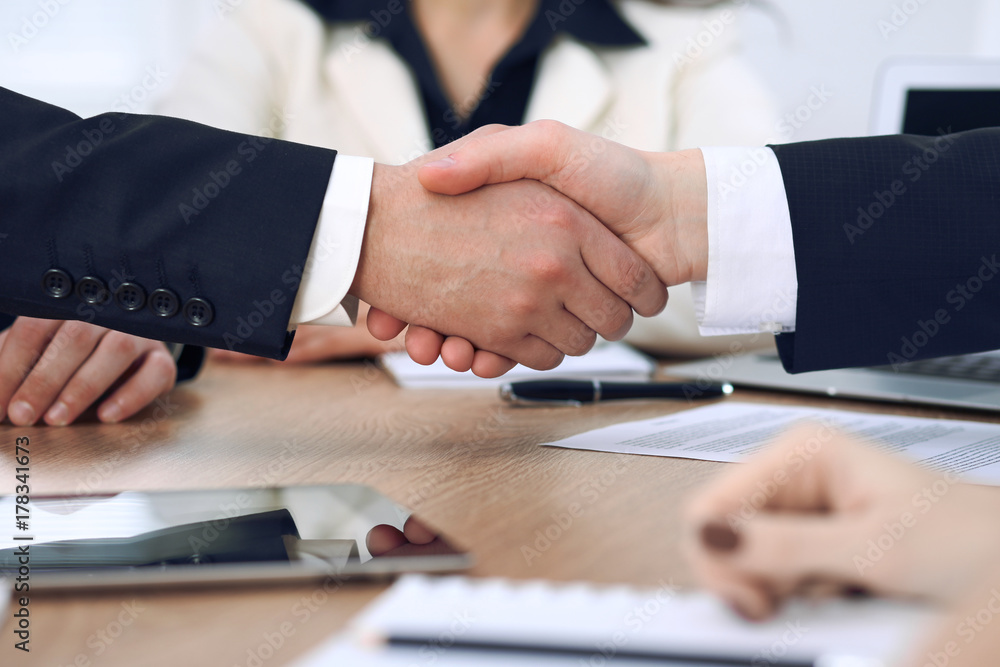 Close up of business people shaking hands at meeting or negotiation in the office. Partners are satisfied because signing contract Close up of business people shaking hands at meeting or negotiation in the office. Partners are satisfied because signing contract