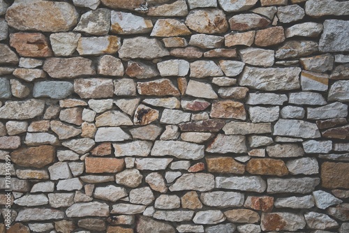 Stone wall background of colorful stones with matt film effect
