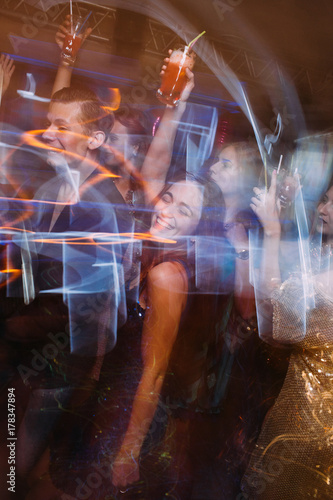 Obraz na plátně Happy party with alcohol at night club in blurred motion