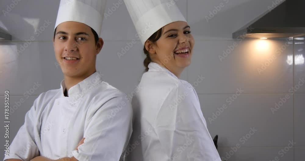 Portrait of two chef cooks working in hospitality industry kitchen Portrait of two chef cooks working in hospitality industry kitchen