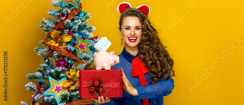 Photos woman showing present box and piggy bank with an euro bill