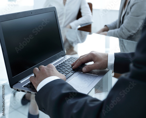 closeup of male hands typing on a laptop.