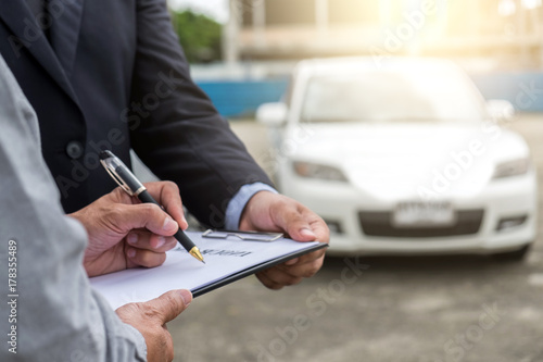 Insurance Agent examine Damaged Car and customer filing signature on Report Claim Form process after accident, Traffic Accident and insurance concept