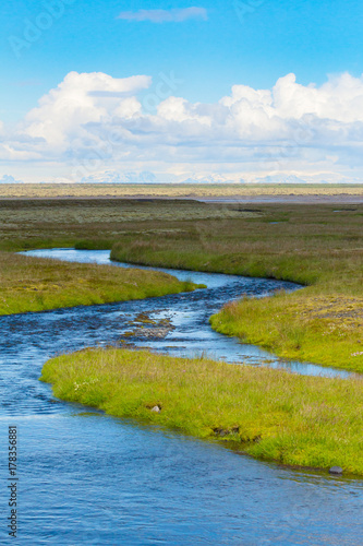 iceland river with glaciers on the horizon