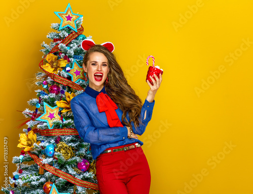 smiling woman with Christmas beverage on yellow background