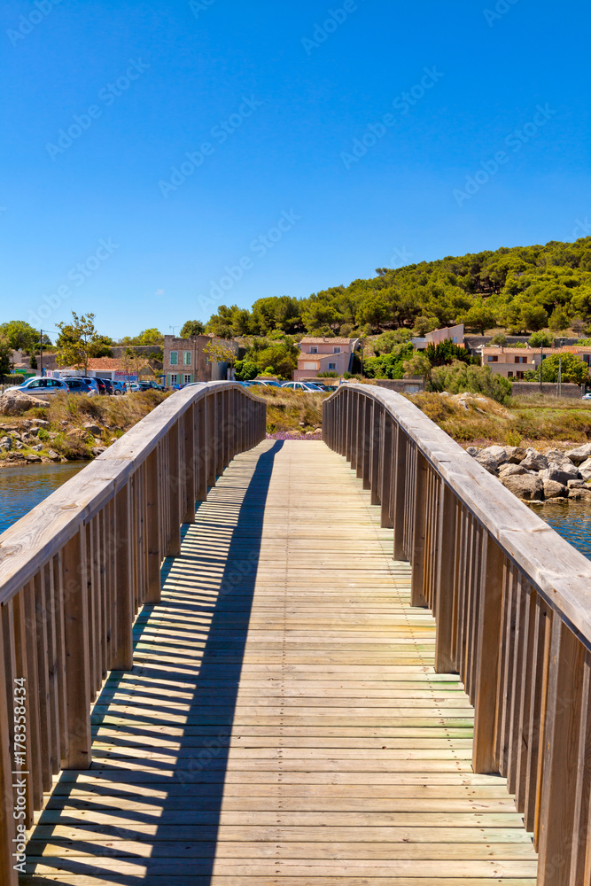 Holzbrücke über einen Wasserzulauf direkt zum Mittelmeer bei der kleinen französischen Ortschaft Gruissan in Südfrankreich