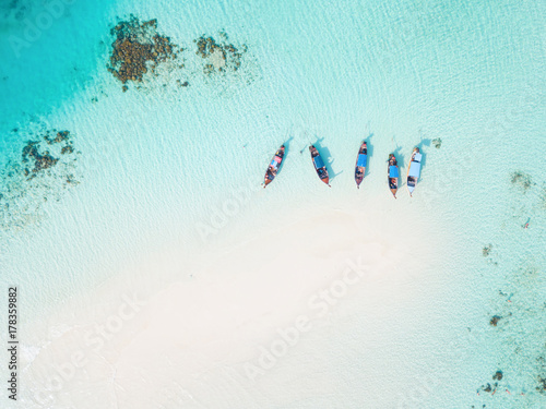 Top view or aerial view of longtail boats on crystal clear water along the sand beach in Phuket Thailand