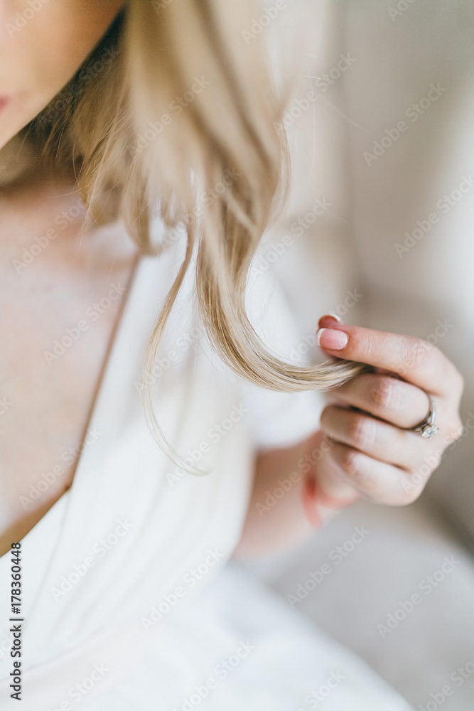 Close up image of beautiful bride holds a earlock. Soft focus on a strand of hair. Artwork
