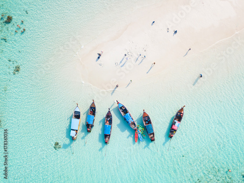 Top view or aerial view of longtail boats on crystal clear water along the sand beach in Phuket Thailand photo