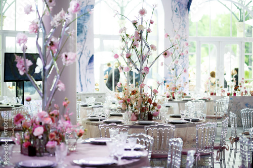 Centerpiece made of pink flowers stands in the middle of pink dinner table © nastasenko