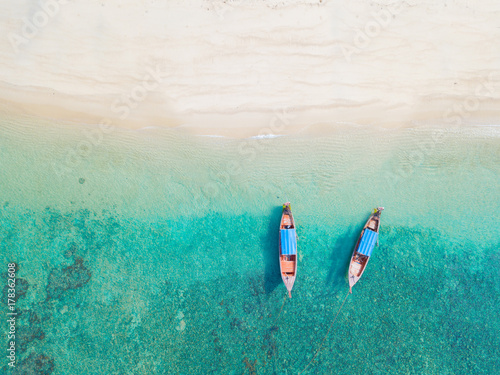 Top view or aerial view of longtail boats on floating on emerald clear water along the sand beach in Phuket Thailand photo