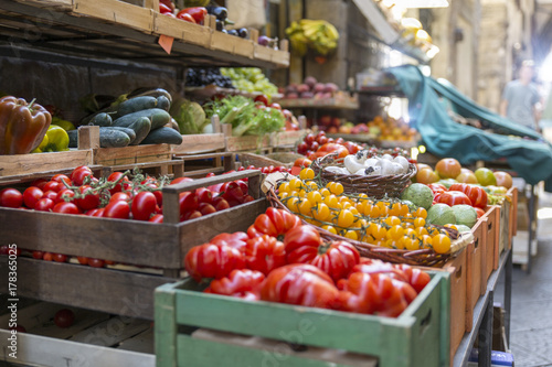Fototapeta Naklejka Na Ścianę i Meble -  Fresh and healthy vegetables and colorful fruit in front of a shop in a picturesque street in Italy