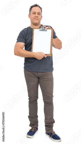 Full body image of man holding a clipboard. He is bald, has overweight and wears dark gray T-shirt..