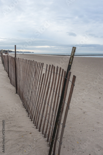 Wooden fence on beach barely standing
