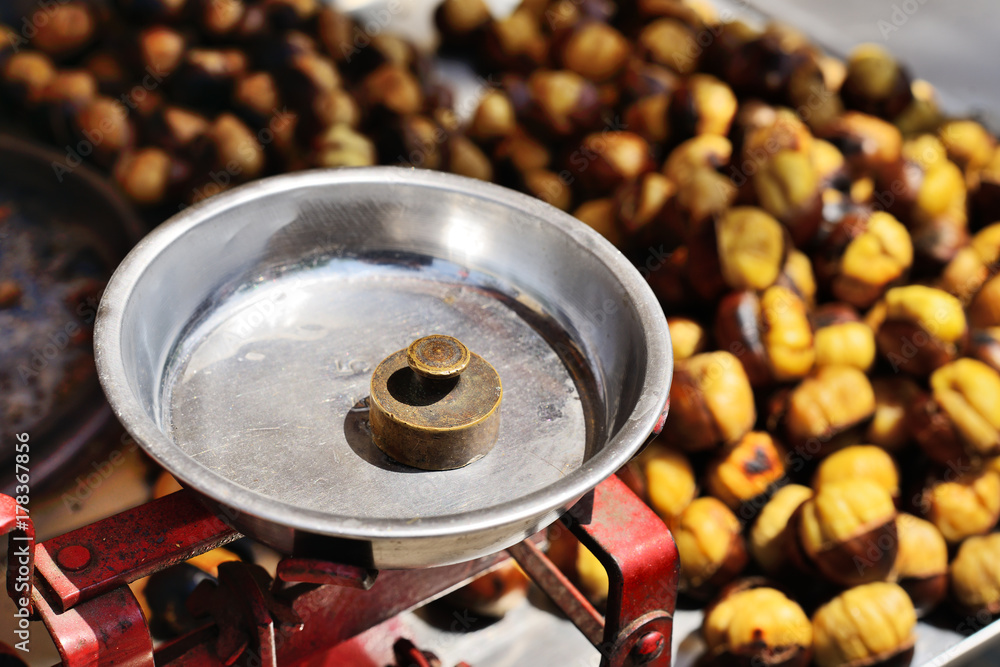 Fresh baked peeled chestnuts and scales with weight on marketplace. Fresh baked peeled chestnuts and scales with weight on marketplace.