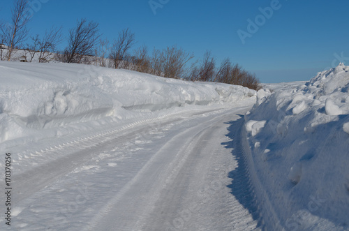 The road is cleared of snow and high drifts.