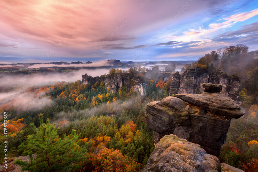 Foggy sunrise in the Saxon Switzerland, Germany, view from the Bastei lookout point. The Bastei is a tourist attraction for over 200 years.