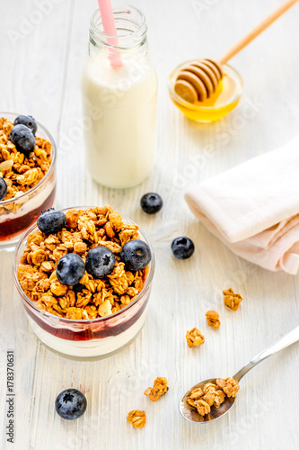 Fitness breakfast with granola, milk and honey on white backgrou