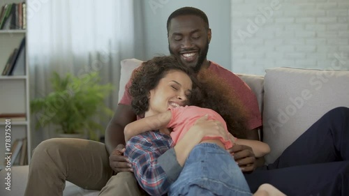 Little biracial daughter running to her parents, parental love and tenderness