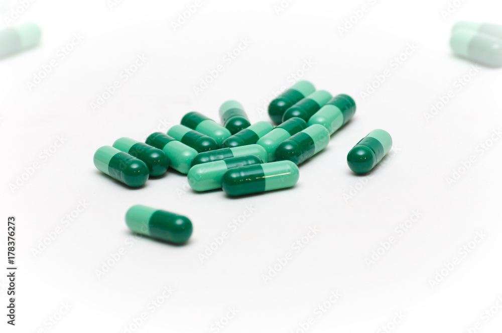 Green Pills Against White Backdrop