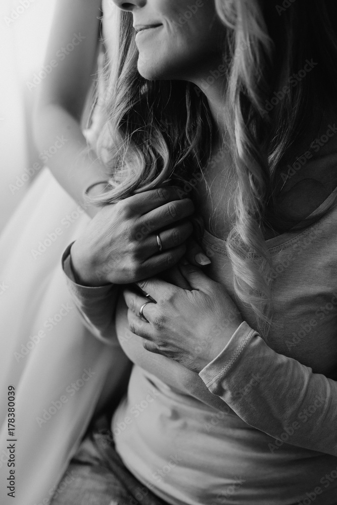Obraz premium Bride on her wedding embrace smiling mom. Senior adult woman holding her daughter's hands near heart. Concept of relationship, love and care