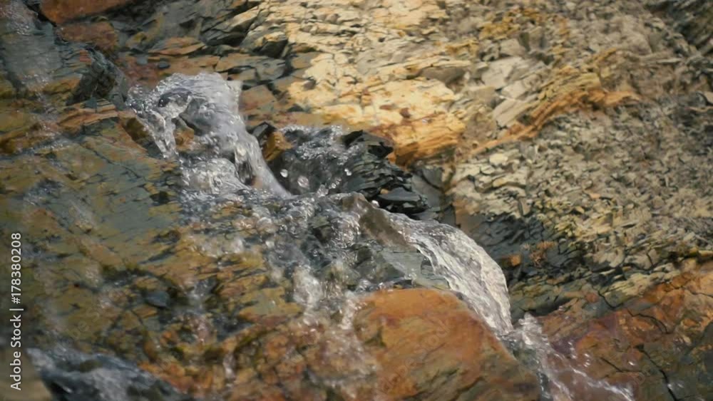 Transparent spring water flows down the stones slow mo Transparent spring water flows down the stones slow mo
