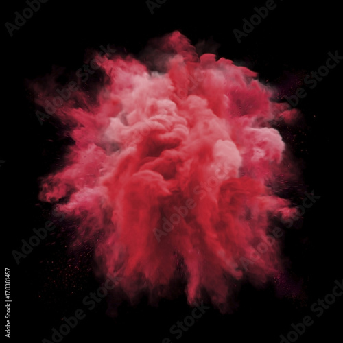 Fotografie Paint powder explosion of red glitter stardust smoke isolated on black background