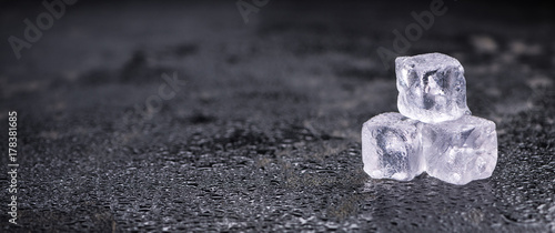 Melting Ice cubes on a vintage slate slab (selective focus) photo