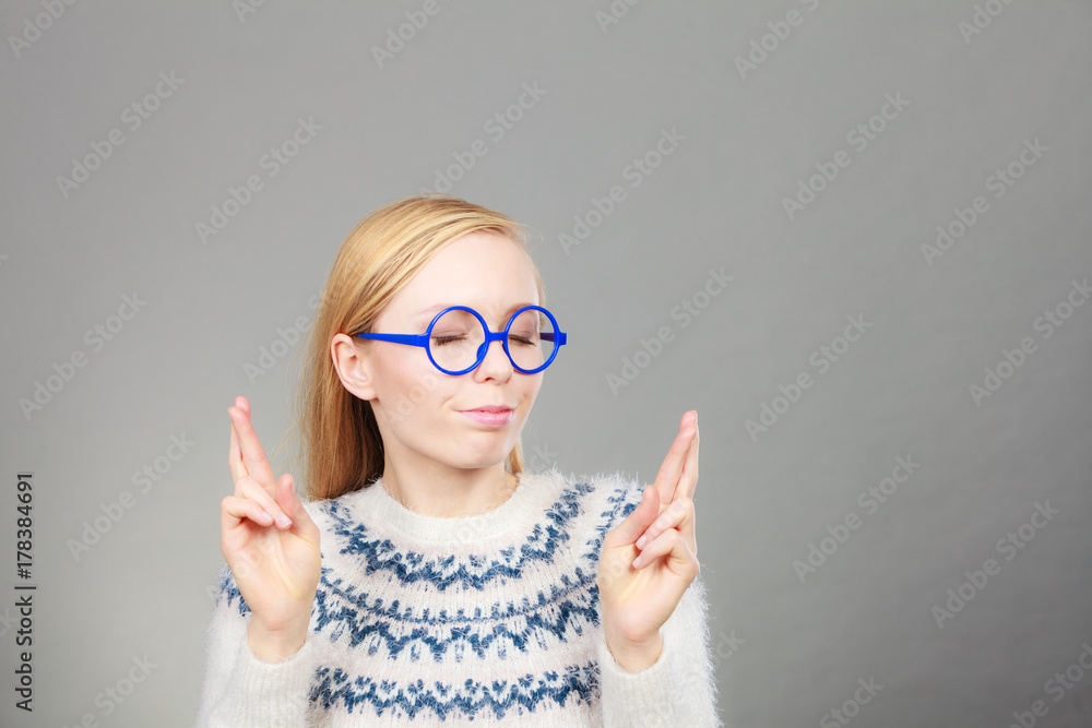 Teenage blonde woman making promise gesture