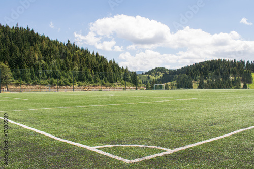 Sports ground in mountains, focus on soccer field