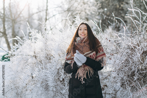 A portrait of a girl with a beautiful smile in the winter, snowly and sunny day on the outdoors.
