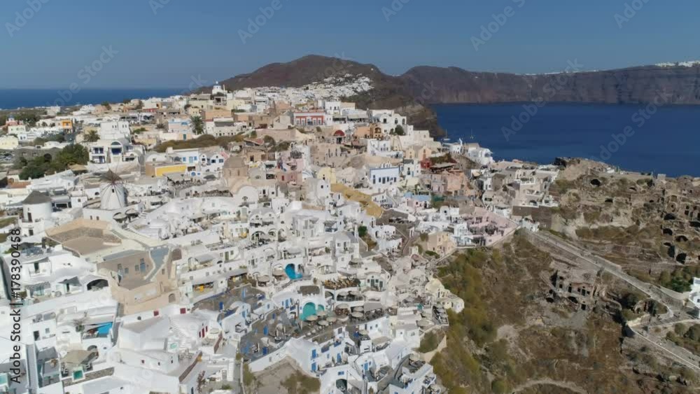 Aerial above white houses and famous old castle ruins, Santorini Island, Greece. Village of Oia Aerial above white houses and famous old castle ruins, Santorini Island, Greece. Village of Oia