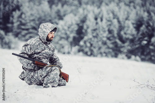 Male hunter in camouflage looking for his target or prey .Winter scene