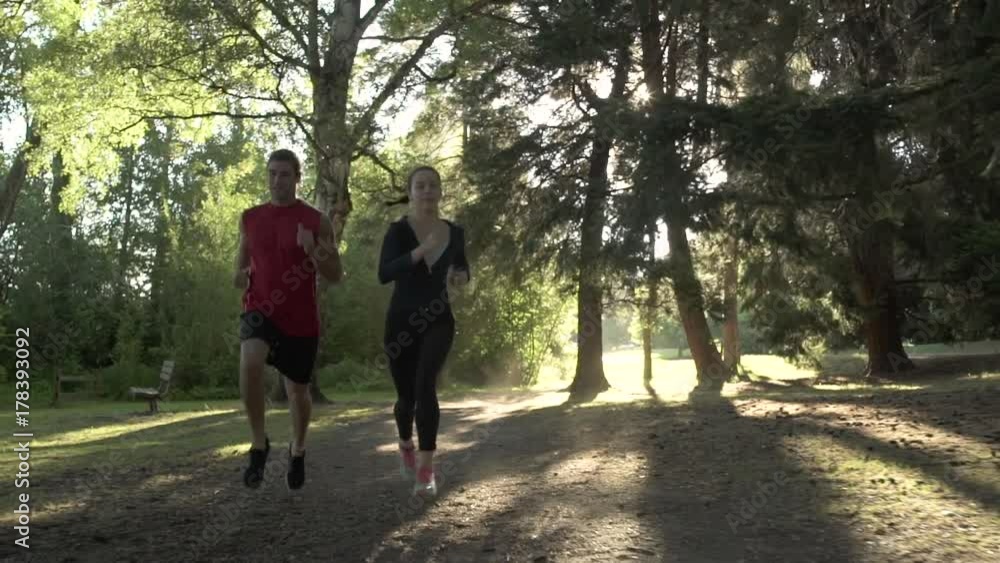 A young man and a woman running in a forest A young man and a woman running in a forest