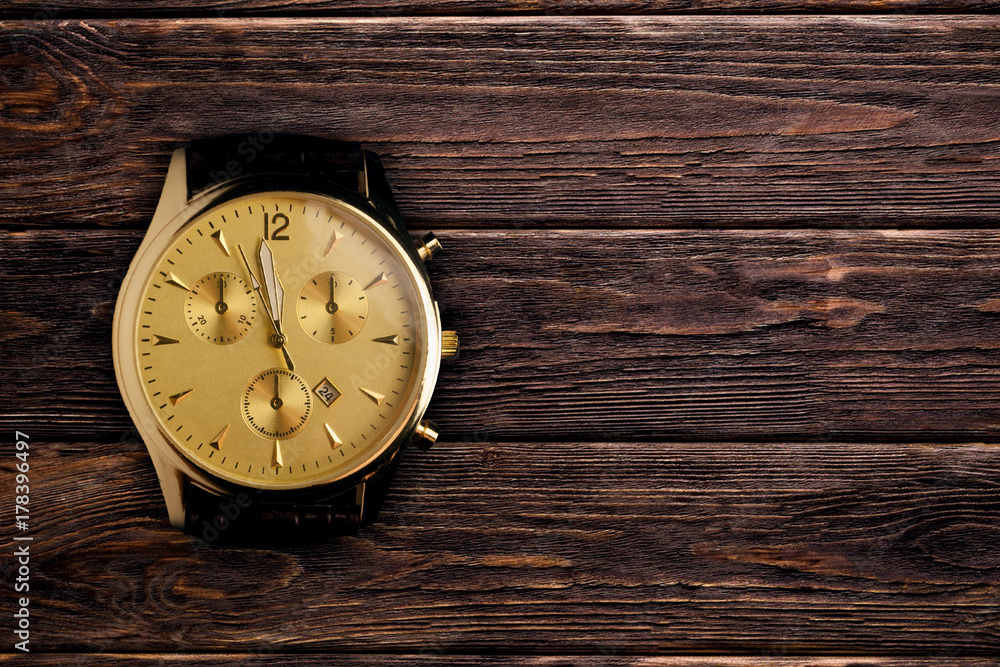luxury wristwatch on the brown wooden background luxury wristwatch on the brown wooden background