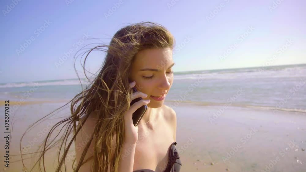 Beautiful woman on beach in a sunny day talking by phone Beautiful woman on beach in a sunny day talking by phone