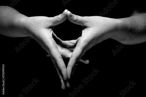 hands in mudra gesture on black background