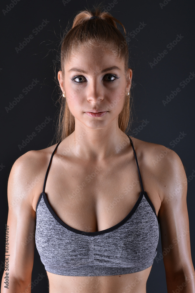 Fototapeta premium Beautiful young sporty sexy woman showing muscle 