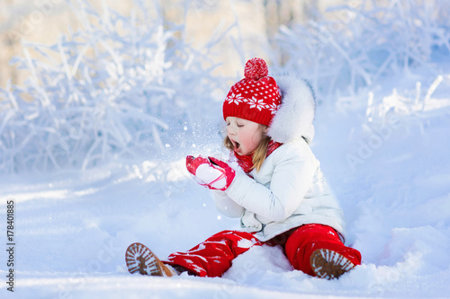 Child playing with snow in winter. Kids outdoors. © famveldman